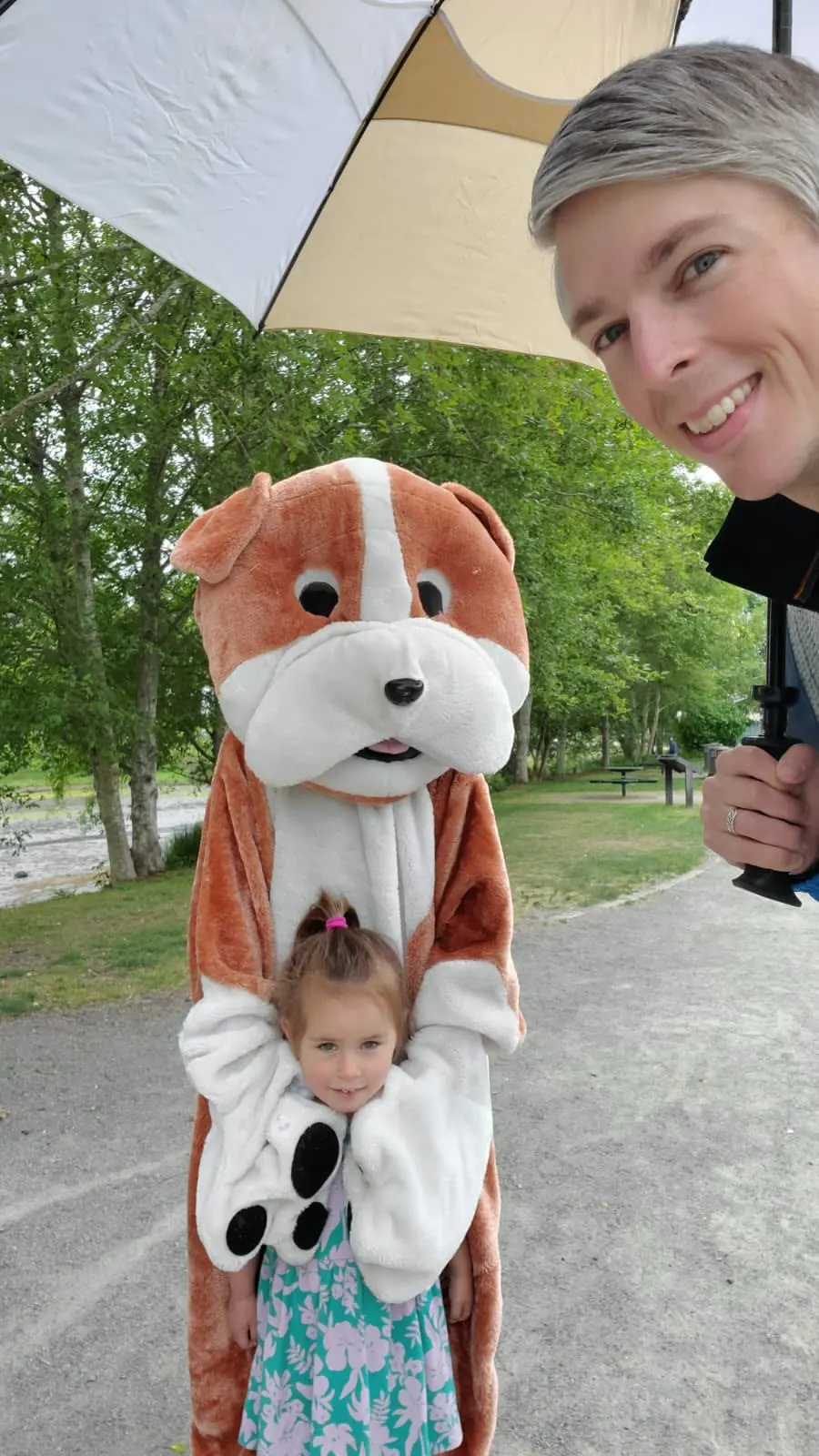 A mascot hugging a little girl at a park event